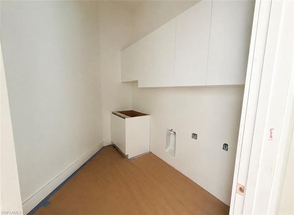 White shaker-style cabinetry, recessed lighting, and a utility hookup