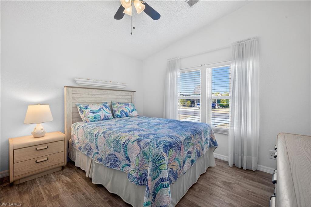 Bedroom with dark wood-style flooring and ceiling fan