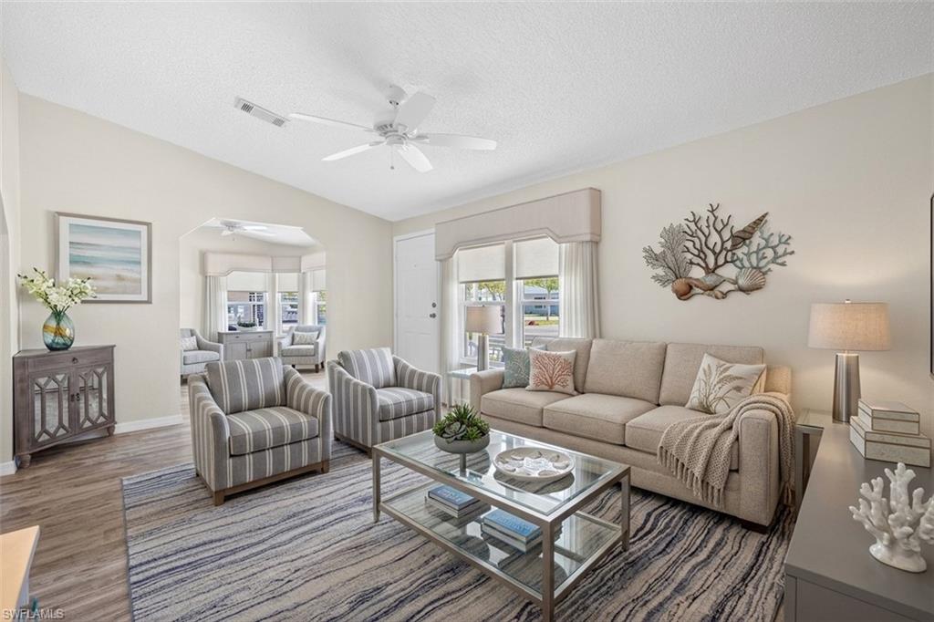 Virtually staged- vaulted ceiling with a ceiling fan, light wood-finish flooring, and natural light from multiple windows