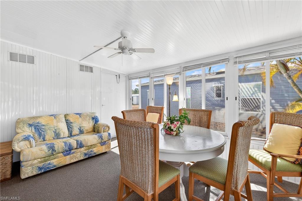 Sunroom / solarium featuring outdoor dining area and a ceiling fan