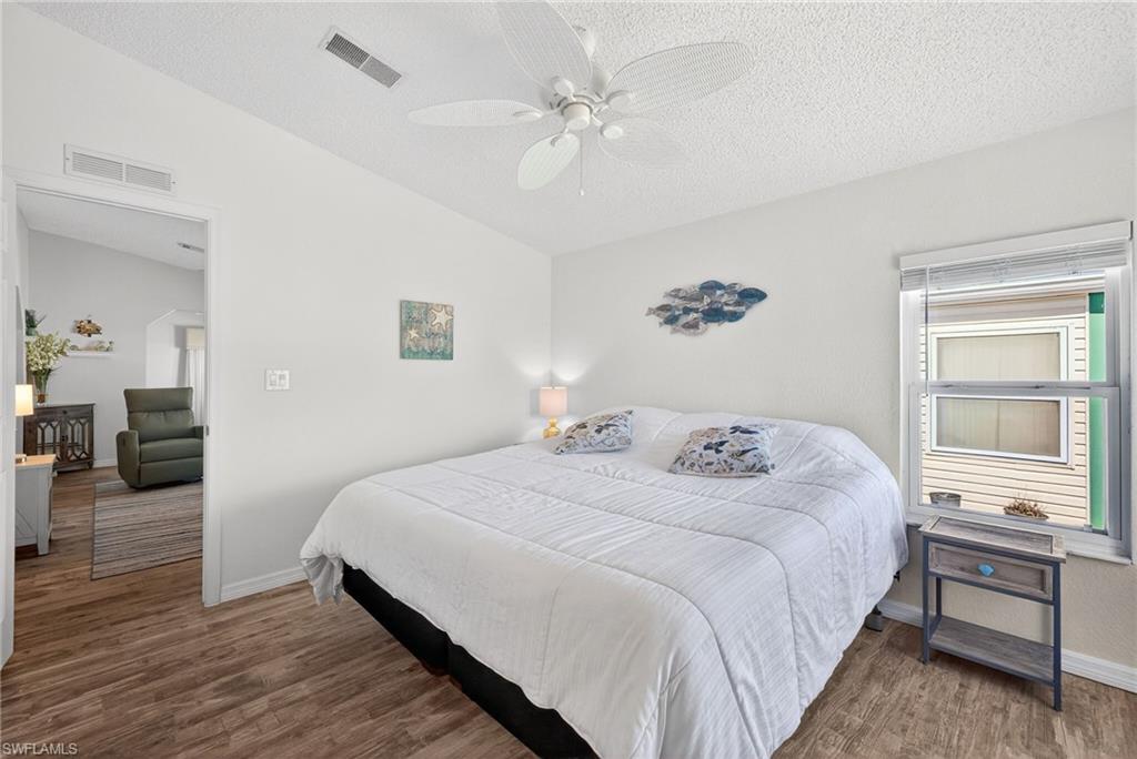 Bedroom with dark wood finished floors and a ceiling fan