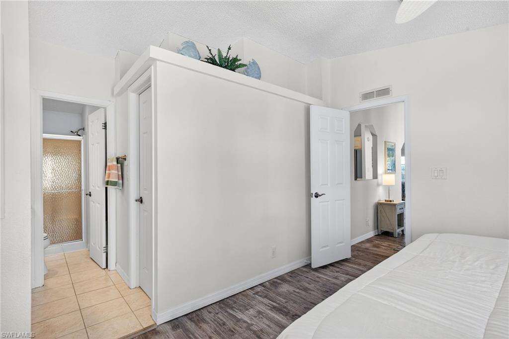 Bedroom featuring wood finished floors, a textured ceiling, ceiling fan, and a closet