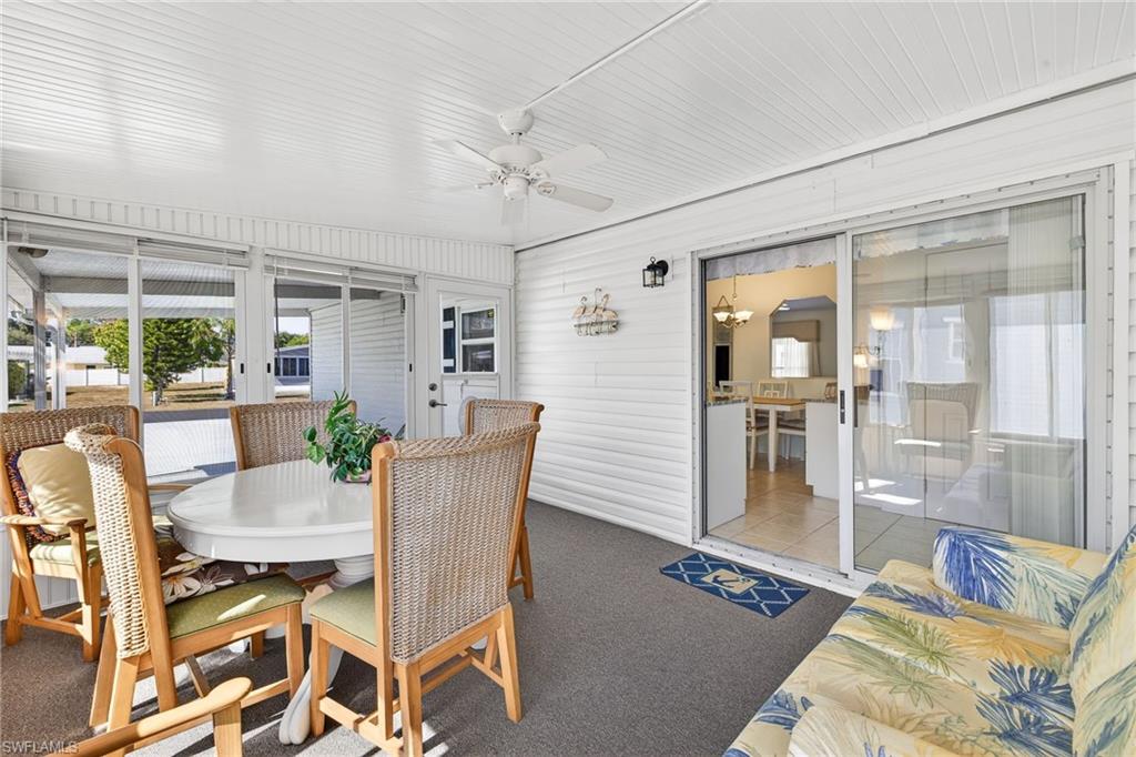 Sunroom with outdoor dining area, a ceiling fan, and hanging lights