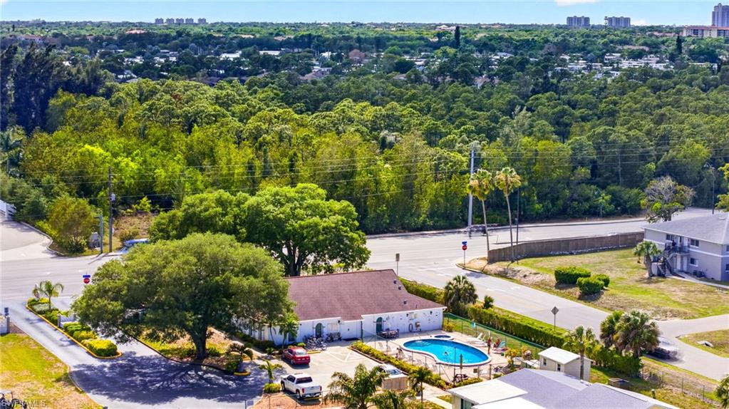 Aerial perspective showcasing a residential community with abundant mature trees and expansive green spaces