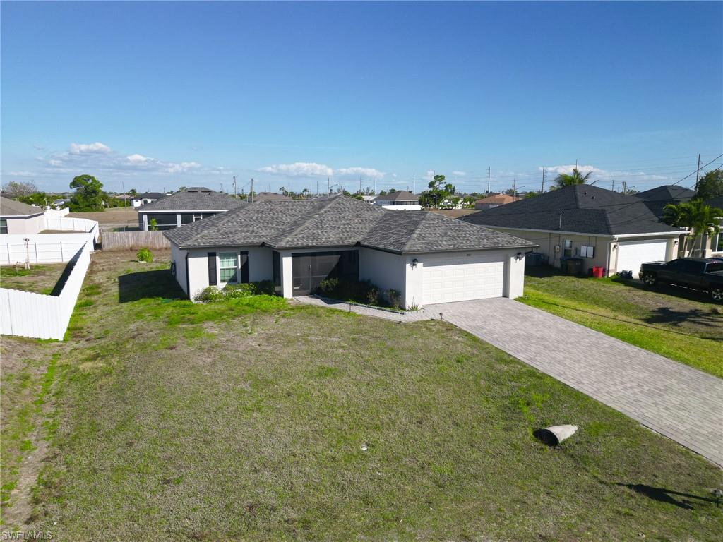 Single story home with a residential view, driveway, an attached garage, a sunroom, and stucco siding