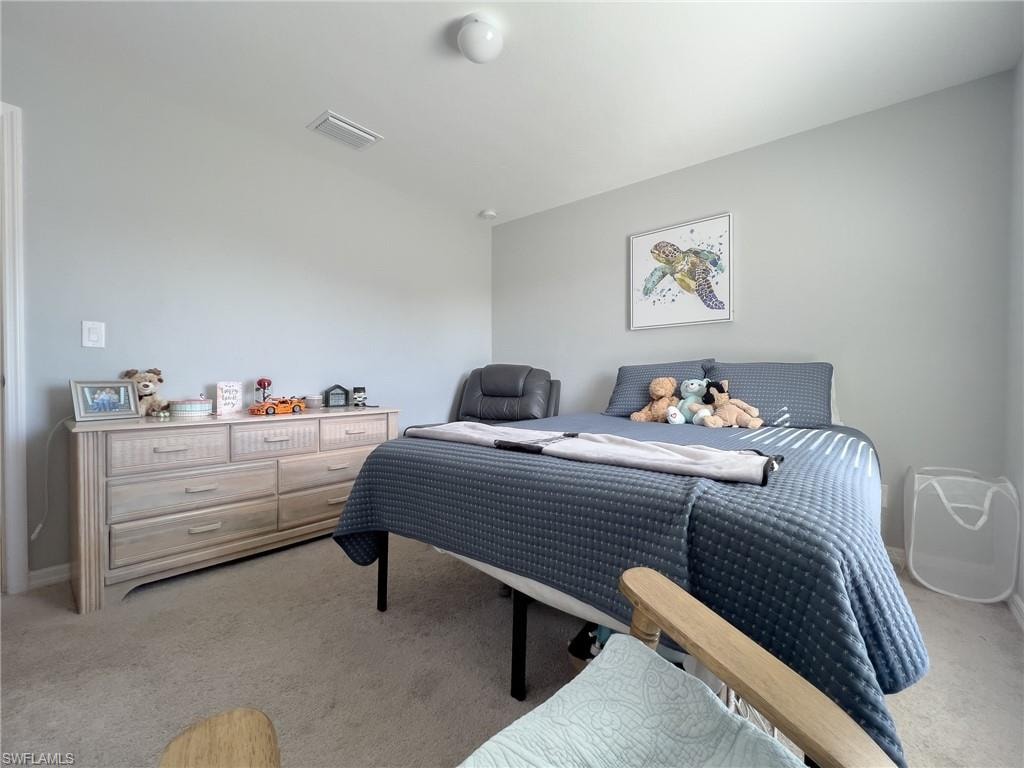 Bedroom featuring light carpet and baseboards