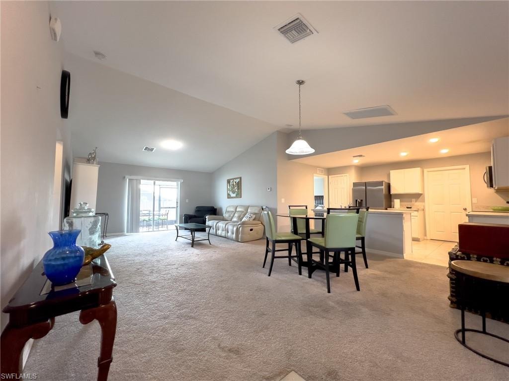 Dining area with light colored carpet, lofted ceiling, and recessed lighting