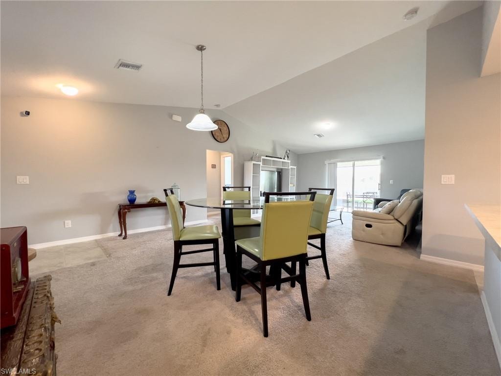 Dining space with baseboards and light colored carpet
