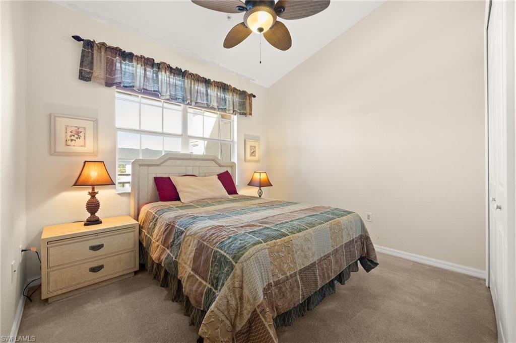 Bedroom with a closet, carpet flooring, lofted ceiling, and ceiling fan