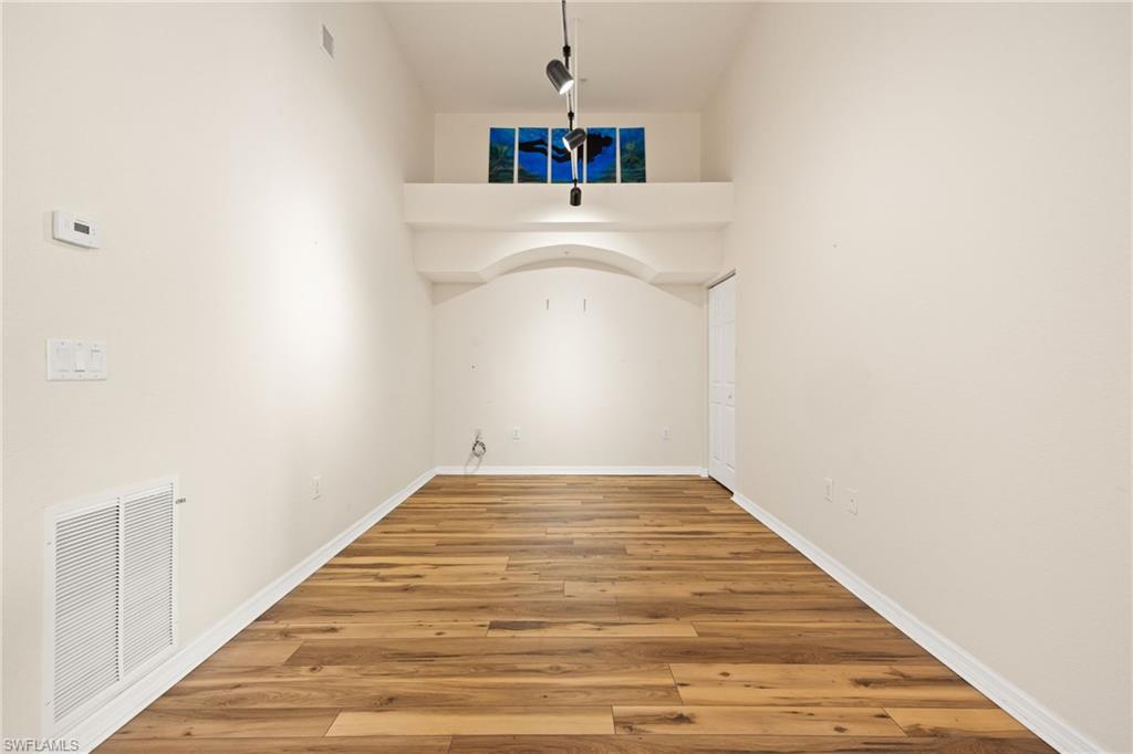 Empty room featuring light wood-style flooring and a high ceiling