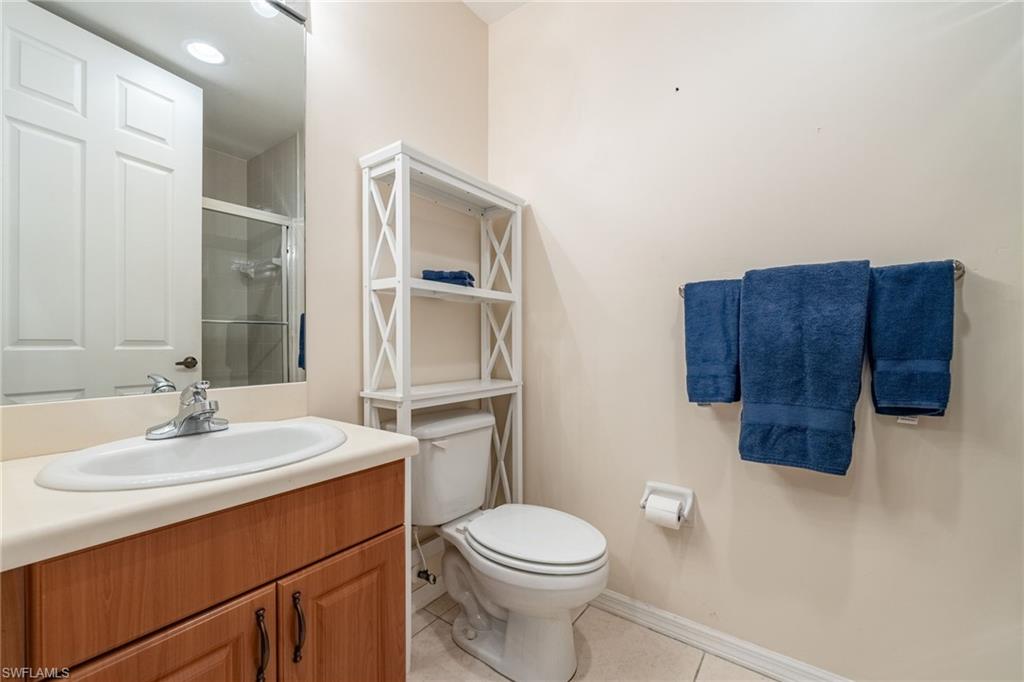 Bathroom with a shower stall, vanity, and light tile patterned flooring