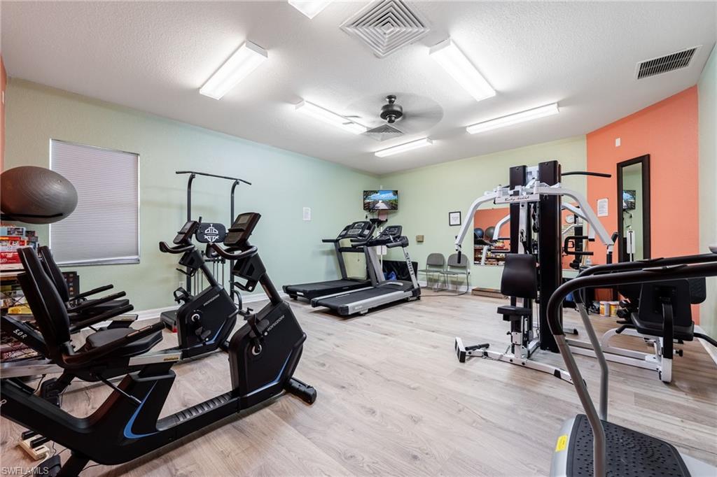 Exercise room featuring ceiling fan and a textured ceiling