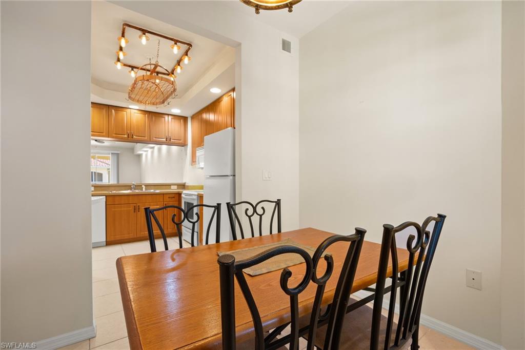 Dinette in Breakfast Room featuring hanging lights, a raised ceiling, and light tile patterned floors