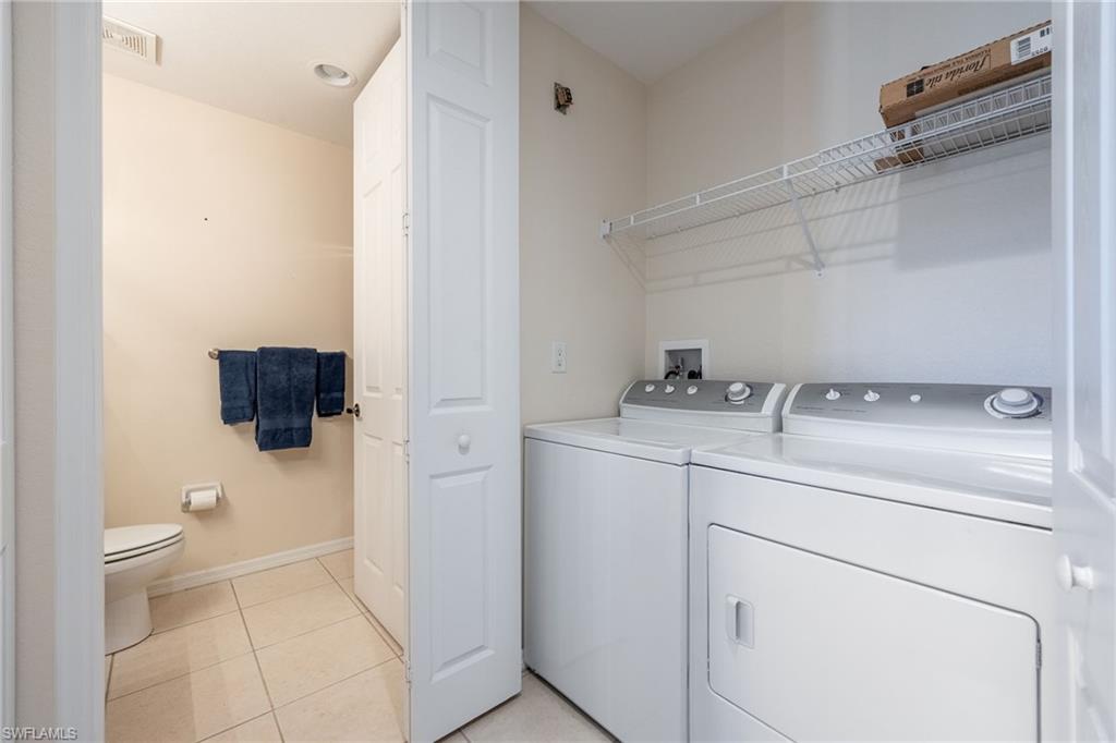 Laundry area featuring light tile patterned flooring and independent washer and dryer