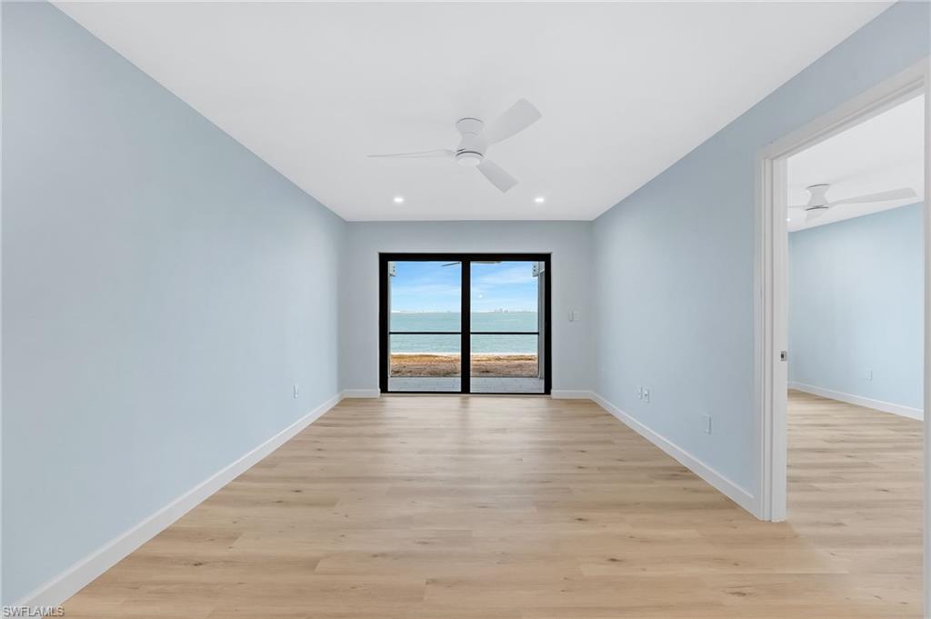 The living area is bright, coastal, and perfectly positioned to capture the waterfront setting.