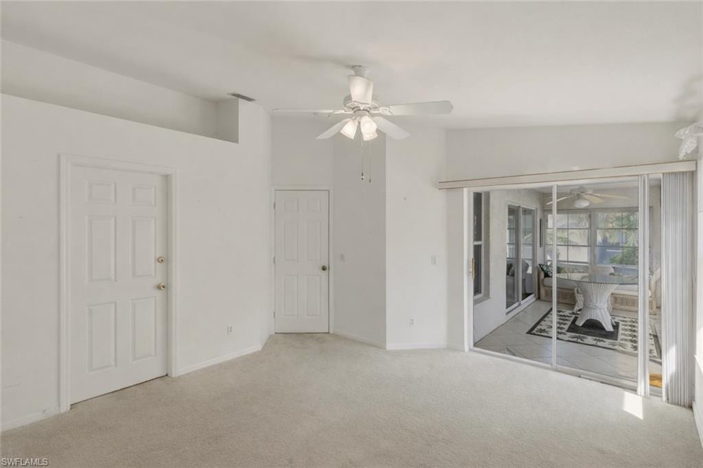 Carpeted empty room with a ceiling fan and baseboards