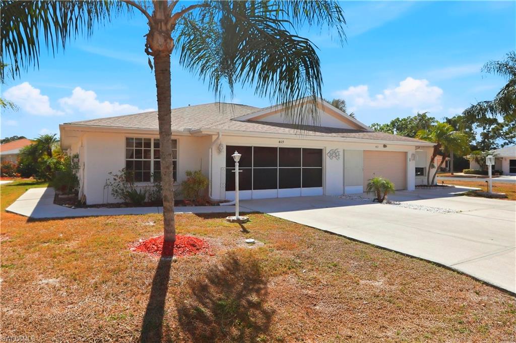 Ranch-style home with concrete driveway, an attached garage, stucco siding, roof with shingles, and a front yard