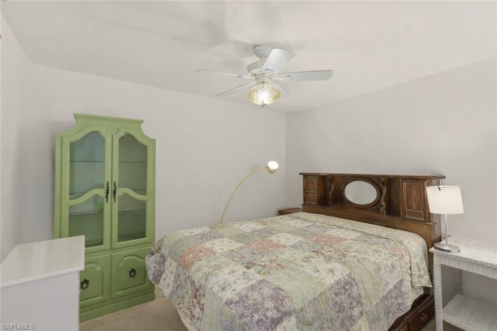 Carpeted bedroom featuring ceiling fan
