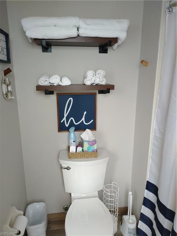 Bathroom featuring curtained shower and wood finished floors