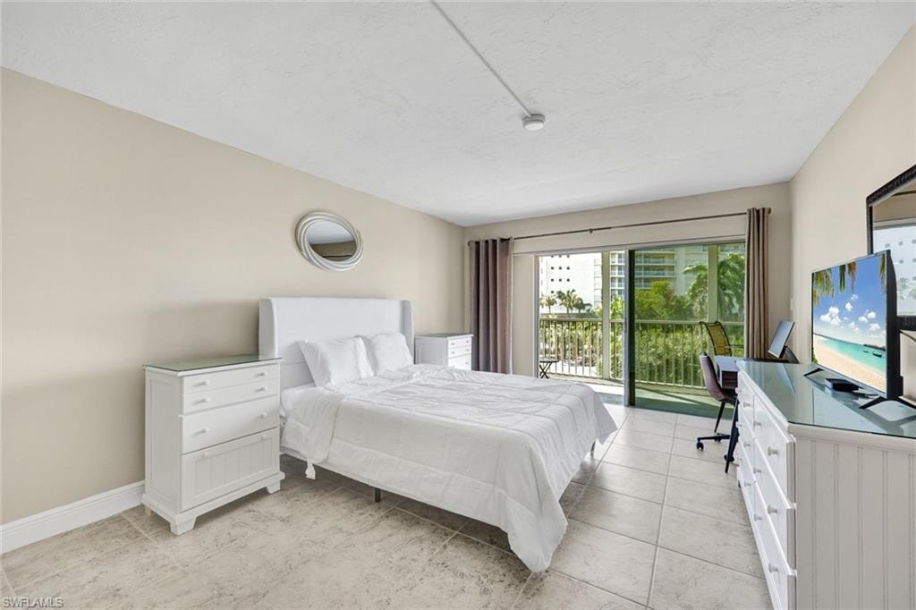 Bedroom with a desk, access to outside, and light tile patterned floors
