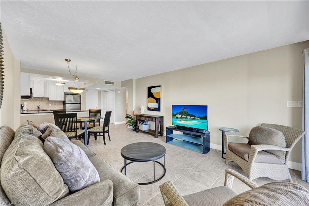 Living area with baseboards and light tile patterned floors