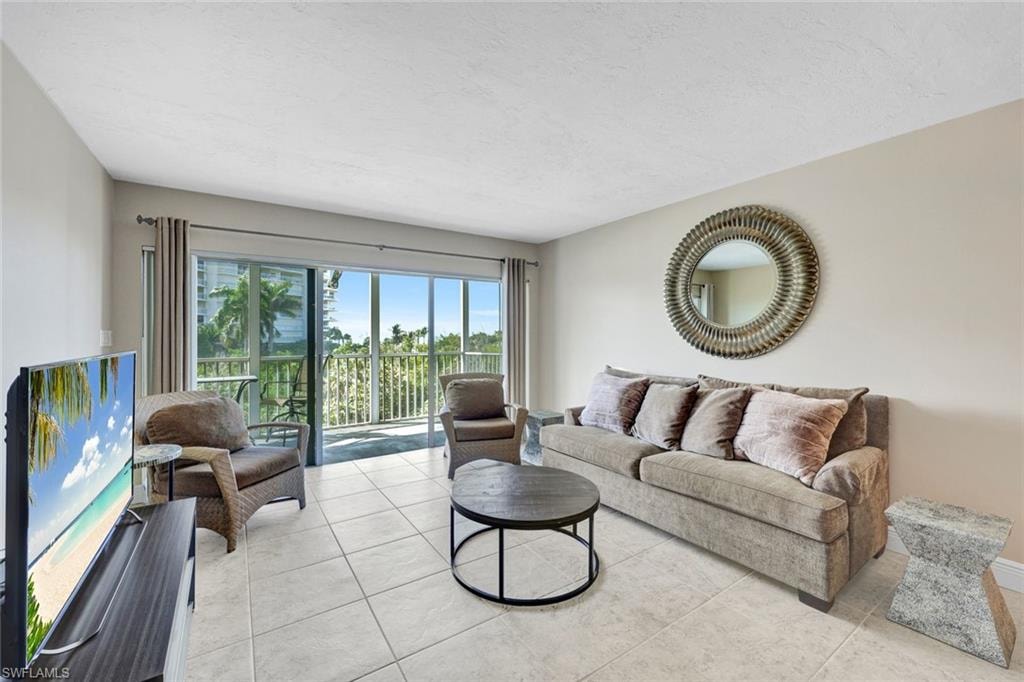 Living area featuring light tile patterned floors and a textured ceiling