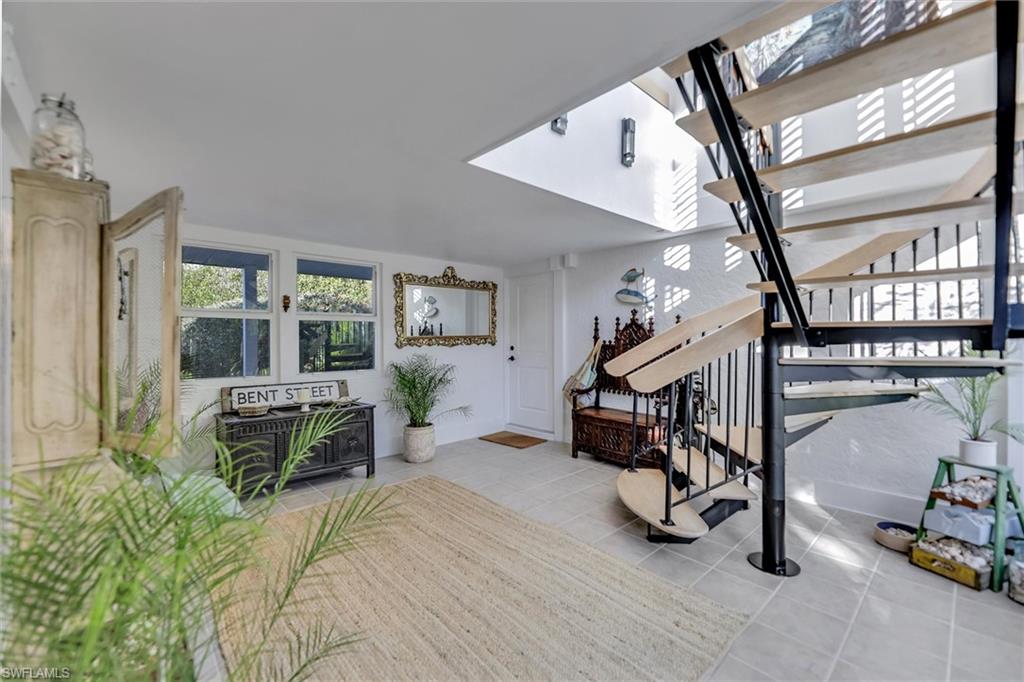 Stairs with plenty of natural light and tile patterned flooring