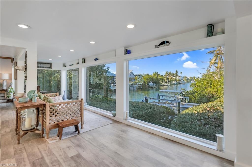 Sunroom / solarium featuring recessed lighting, a water view, and wood finished floors