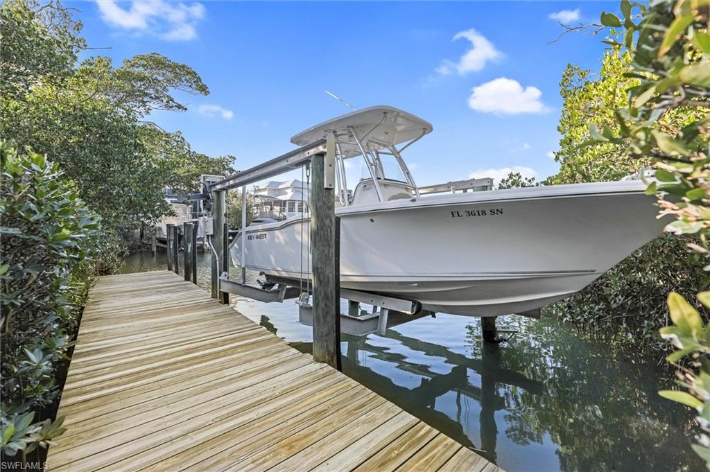 Dock featuring boat lift and a water view