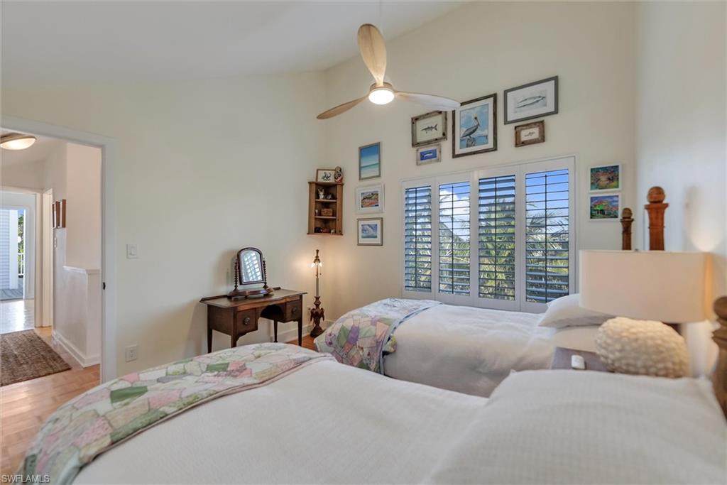 Bedroom featuring lofted ceiling, parquet floors, and a ceiling fan