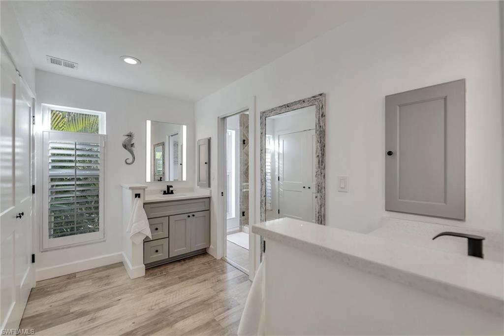 Full bathroom featuring vanity, a stall shower, light wood-type flooring, and recessed lighting