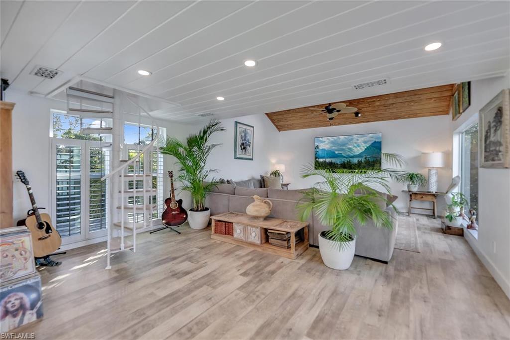 Living room featuring lofted ceiling, recessed lighting, wood finished floors, and a ceiling fan