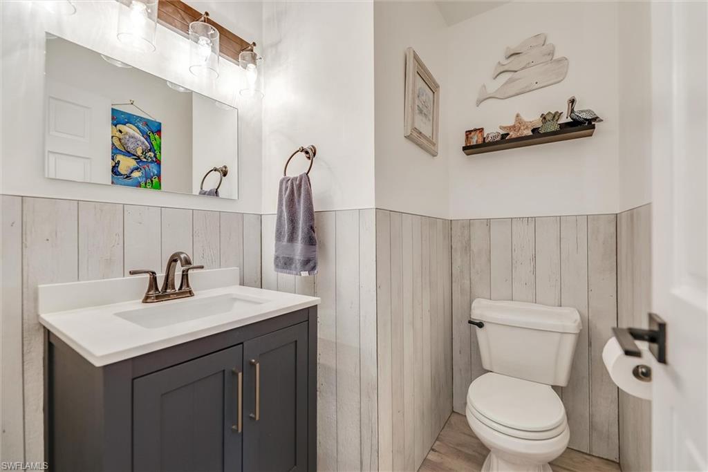 Bathroom featuring vanity, wood finished floors, and wooden walls