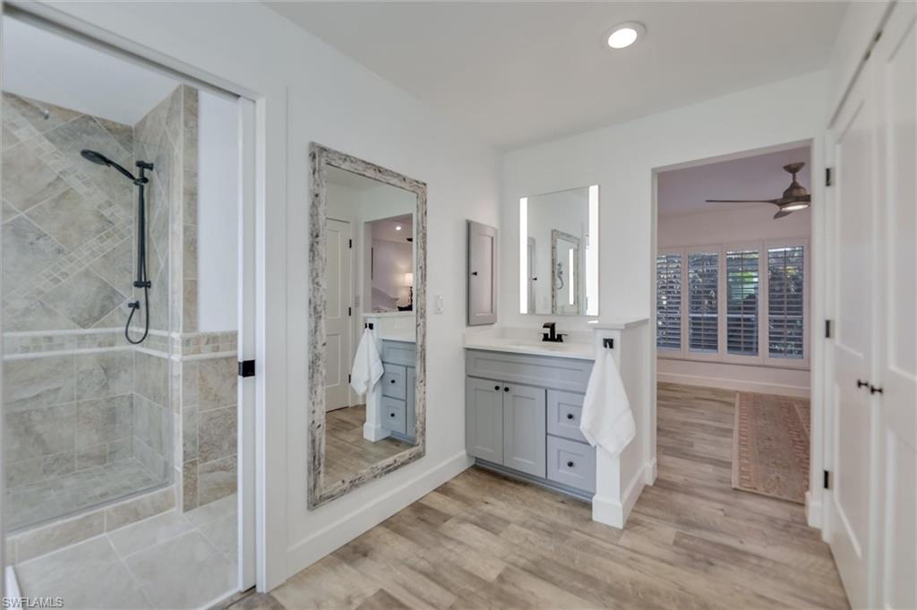 Bathroom with a shower stall, vanity, light wood-style floors, recessed lighting, and ceiling fan
