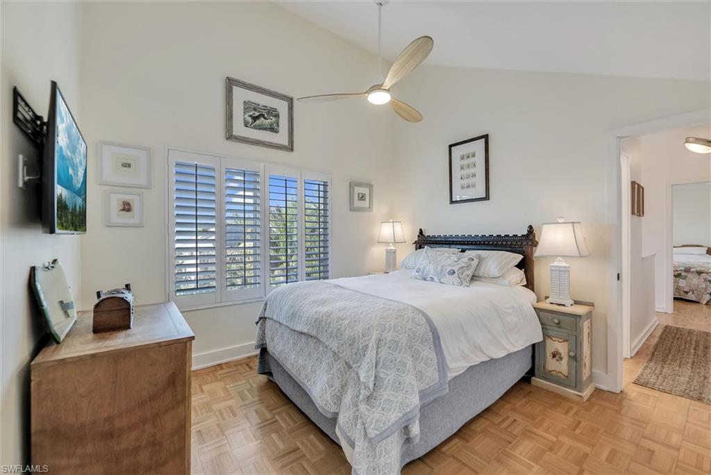 Bedroom featuring parquet floors, lofted ceiling, and a ceiling fan