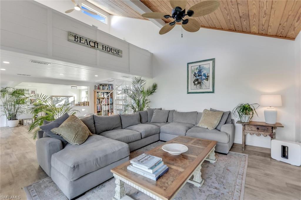 Living area with a ceiling fan, wood finished floors, and a vaulted wood ceiling