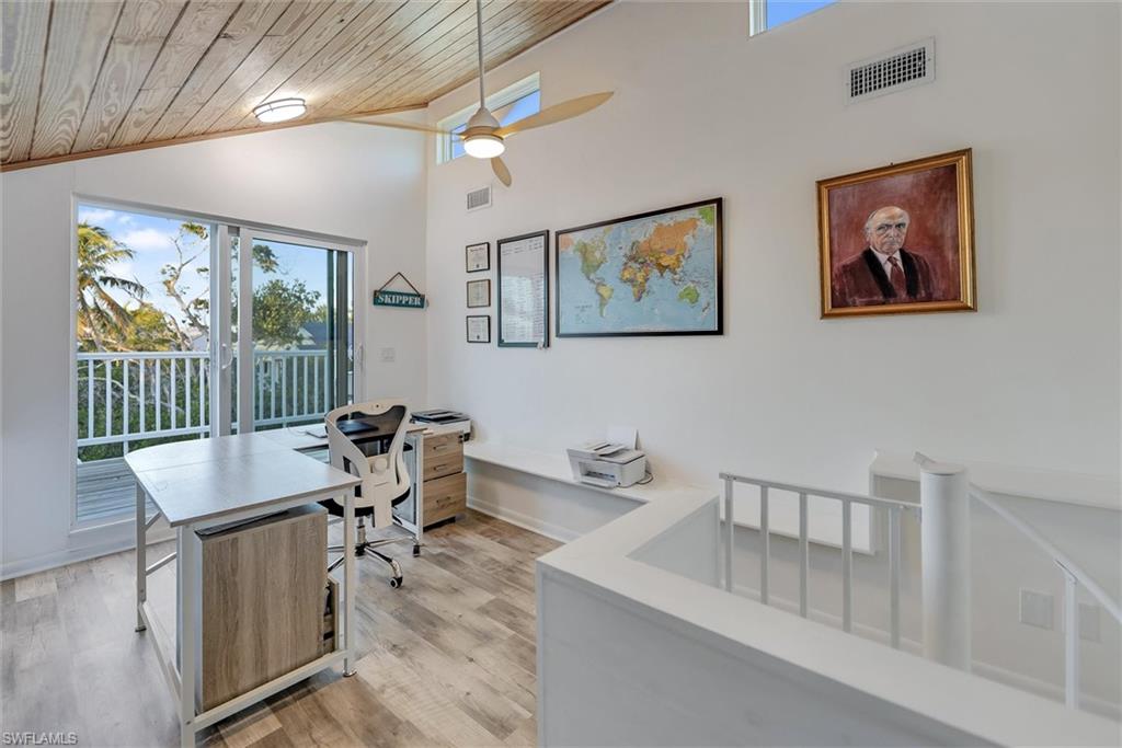 Office area featuring ceiling fan, light wood-style floors, and a vaulted wooden ceiling
