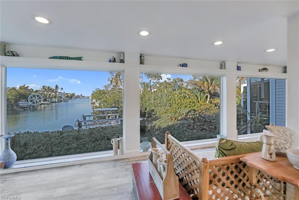 Sunroom with recessed lighting, wood finished floors, and a water view