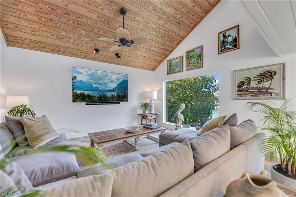 Living area with ceiling fan and a vaulted wood ceiling
