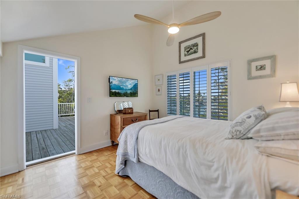 Bedroom with access to exterior, parquet floors, lofted ceiling, and a ceiling fan