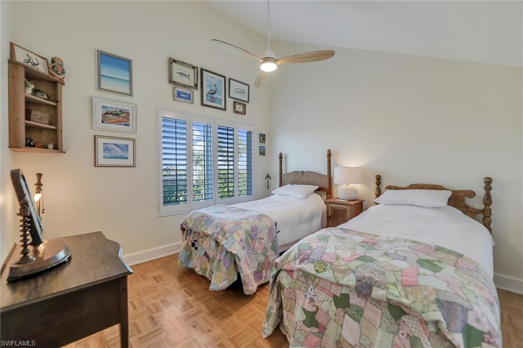 Bedroom with parquet floors, vaulted ceiling, and a ceiling fan
