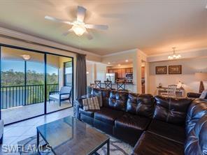 Living room featuring ceiling fan with notable chandelier and ornamental molding