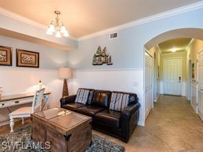 Living room featuring a notable chandelier and crown molding