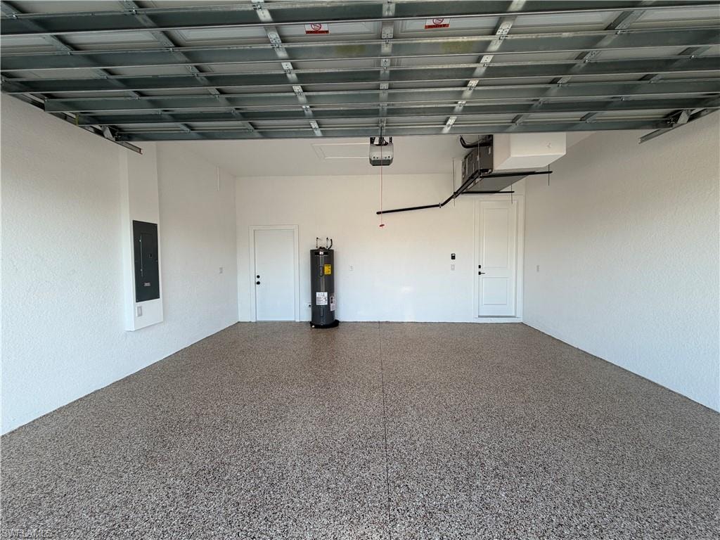 Garage featuring electric panel and water heater