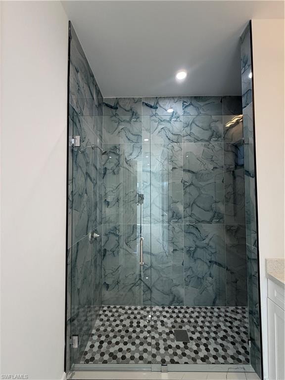 Full bathroom featuring a marble finish shower, vanity, and recessed lighting