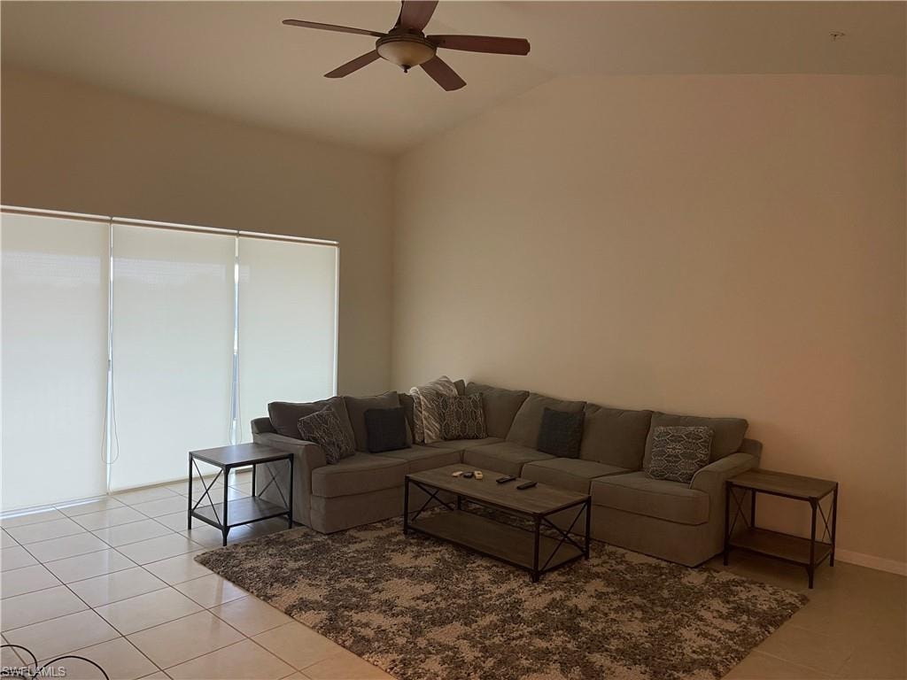 Great room featuring a ceiling fan, lofted ceiling, and light tile patterned flooring