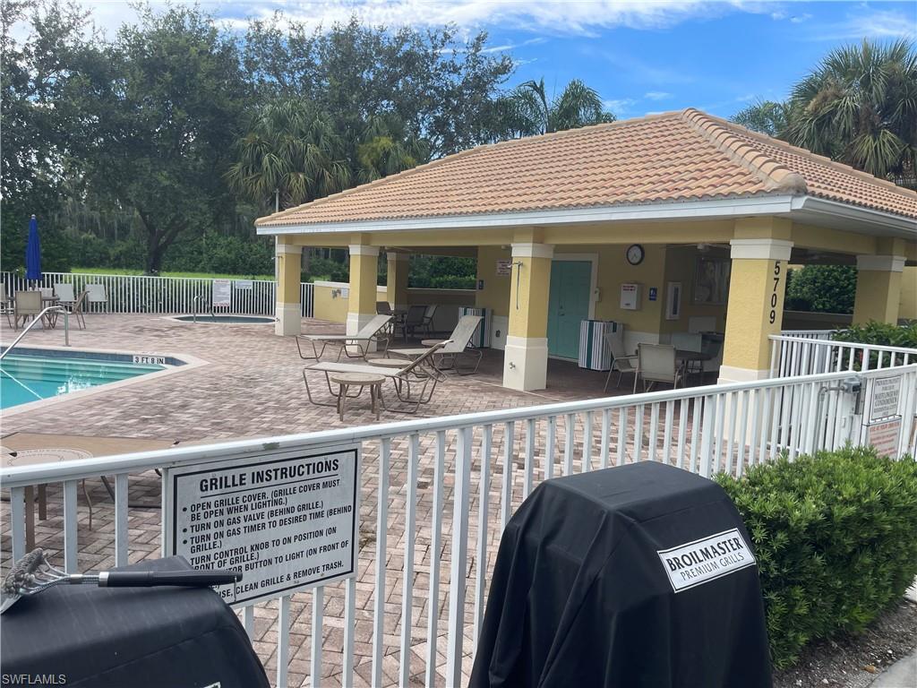 View of patio with area for grilling and a community pool