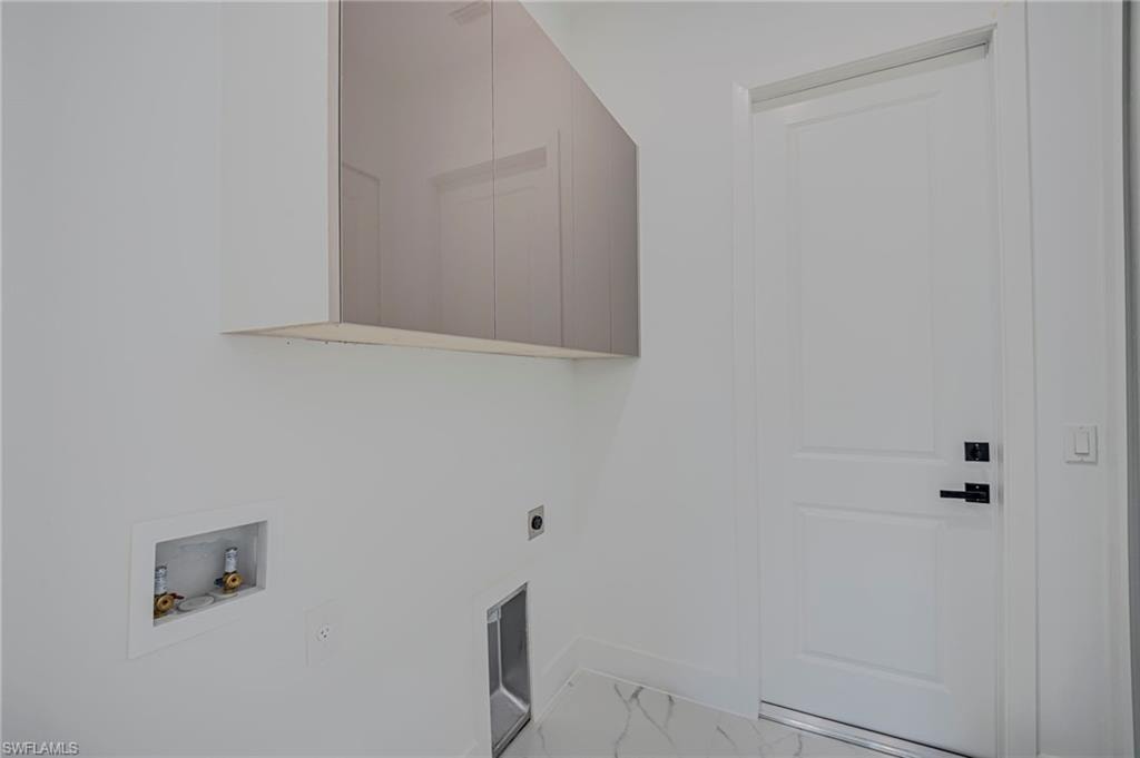 Laundry area with washer hookup, hookup for an electric dryer, light marble finish flooring, and cabinet space