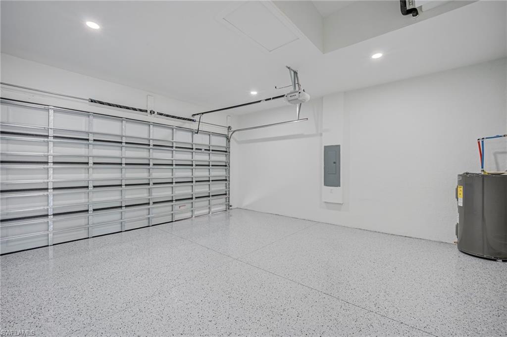 Garage featuring electric water heater, recessed lighting, and electric panel