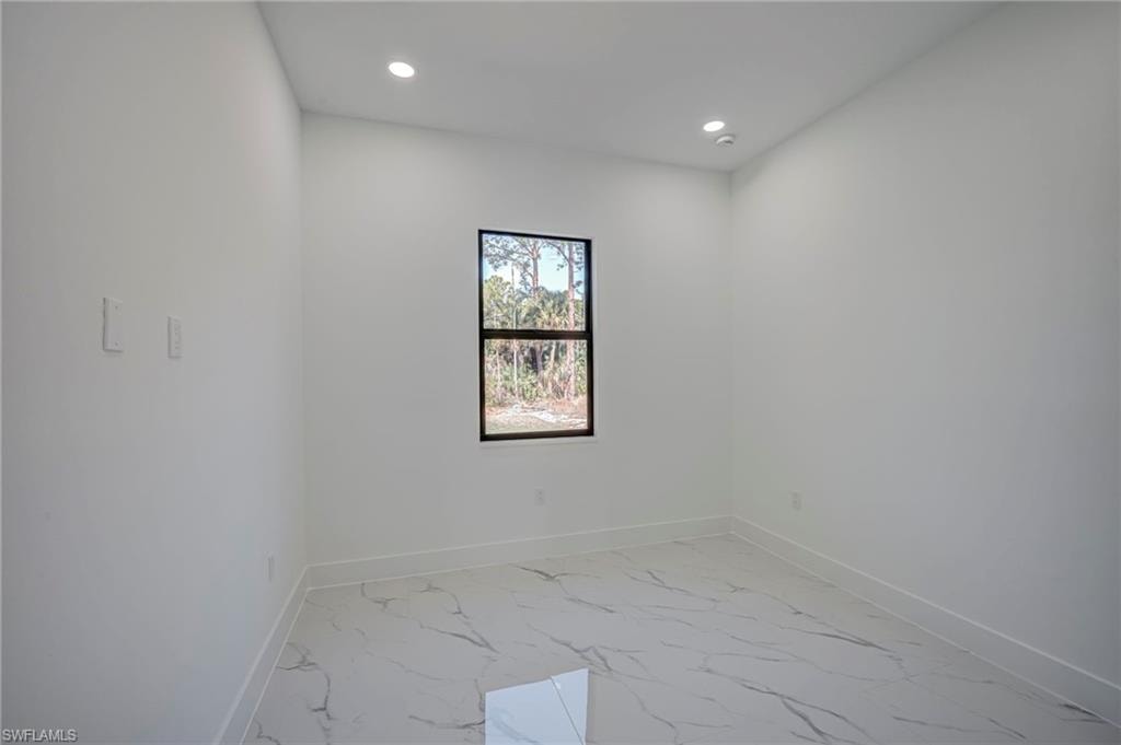 Empty room featuring light marble finish floors and recessed lighting